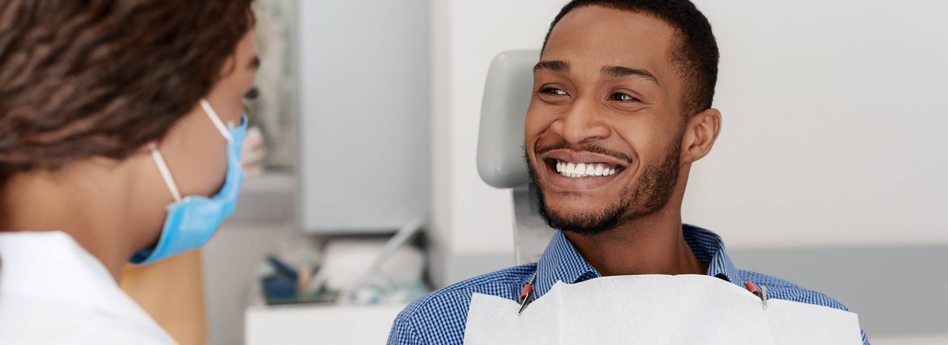 A man is smiling happily after tooth extractions.