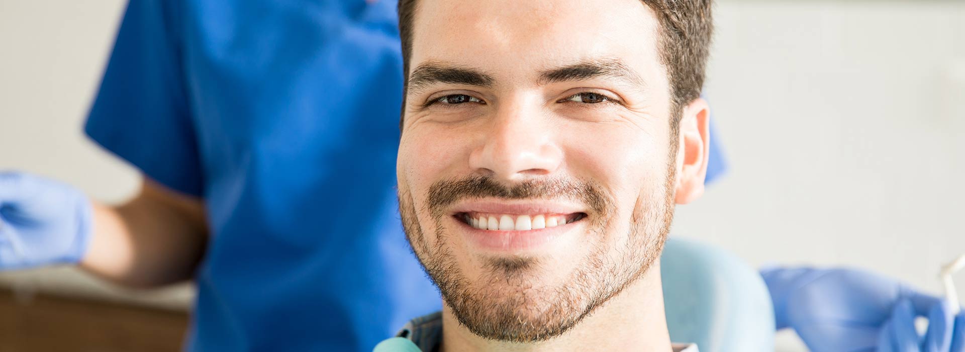 A man is smiling happily after dental bridges treatment.
