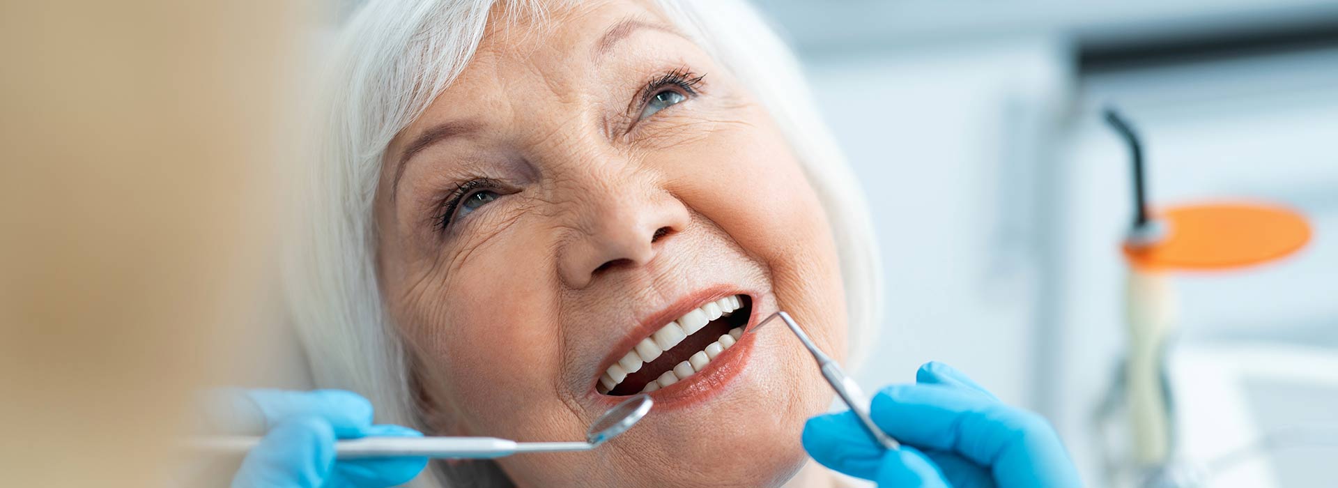 A senior woman is smiling happily after implant restorations.